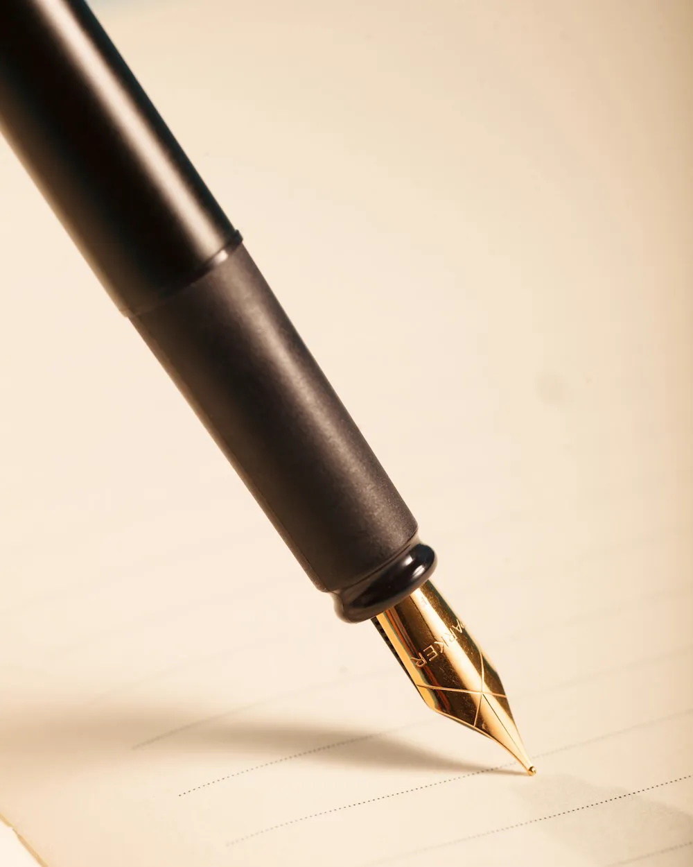 La plume d'un stylo posée sur une feuille de papier